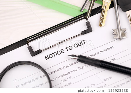 Notice to quit or eviction notice blank on A4 tablet lies on office table with pen and magnifying glass close up Notice to quit or eviction notice blank on A4 tablet lies on office table with pen and magnifying glass close up 135923388