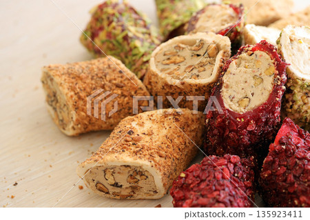 Many rolls of turkish delight with different flavors and fillings close up on table. Cutted Turk Lokumu bars 135923411