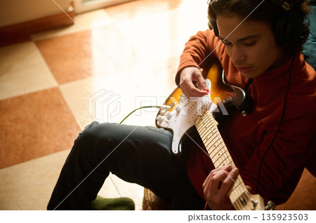 Teen Guitarist With Headphones Playing Electric Guitar At Home Studio Session 135923503