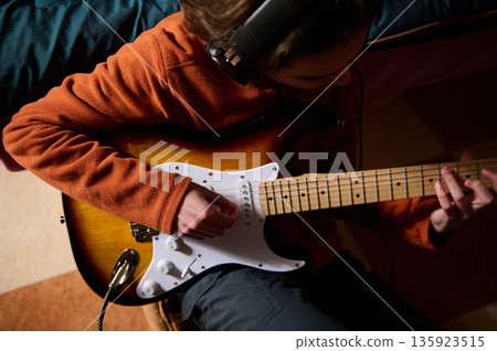 Teen Guitar Player With Orange Hoodie Enjoying Electric Guitar Session 135923515