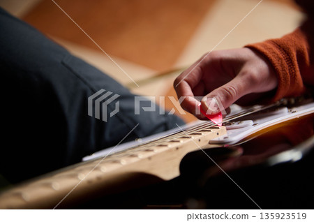 Teen Guitarist Hands With Pink Pick Playing Electric Guitar In Focus Teen Guitarist Hands With Pink Pick Playing Electric Guitar In Focus 135923519