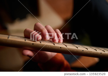 Teenage Middle Eastern Boy Playing Guitar, Focused On The Neck And Frets, Music Hobby Teenage Middle Eastern Boy Playing Guitar, Focused On The Neck And Frets, Music Hobby 135923520