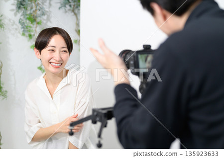Male photographer taking a photo of a smiling woman Male photographer taking a photo of a smiling woman 135923633