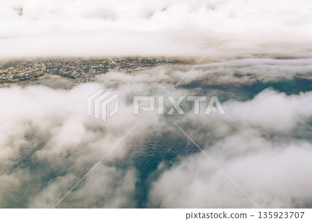 Aerial view of Cape Town covered in low-lying cloud. Cityscape and ocean from above with fog. South Africa luxury travel vacation. 135923707