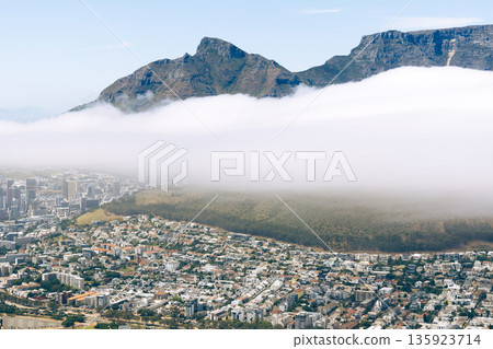 Aerial view of Cape Town city with Table Mountain and clouds covering the base. Beautiful panoramic landscape of South Africa for travel concept. 135923714