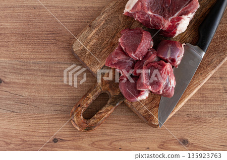 raw beef meat, sliced on a cutting board, with a knife, no spices, no herbs, top view, wooden table, homemade, no people, raw beef meat, sliced on a cutting board, with a knife, no spices, no herbs, top view, wooden table, homemade, no people, 135923763