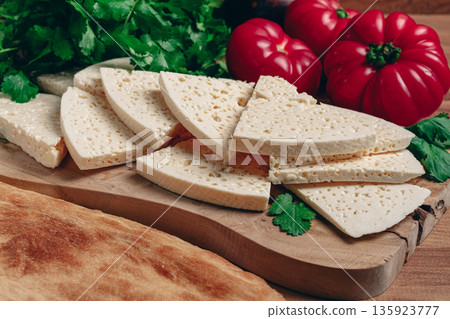 Georgian sliced cheese,on a wooden chopping board, with tomatoes with herbs and lavash, rustic style, Georgian cuisine, no people Georgian sliced cheese,on a wooden chopping board, with tomatoes with herbs and lavash, rustic style, Georgian cuisine, no people 135923777