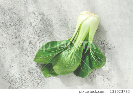 Fresh bok choy, laid out on a light gray surface, top view, natural light, 135923783