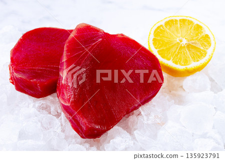 Fresh tuna and lemon, on ice ready, for preparation, at a seafood market Fresh tuna and lemon, on ice ready, for preparation, at a seafood market 135923791