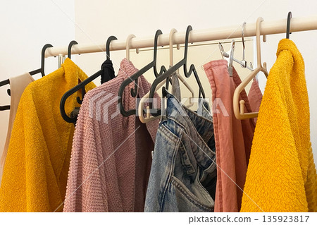 Everyday clothing items hanging on a clothes rack Everyday clothing items hanging on a clothes rack 135923817