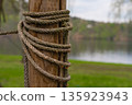 Closeup of weathered rope wrapped around wooden post by lake in Nova Zivohost, Czech Republic 135923943