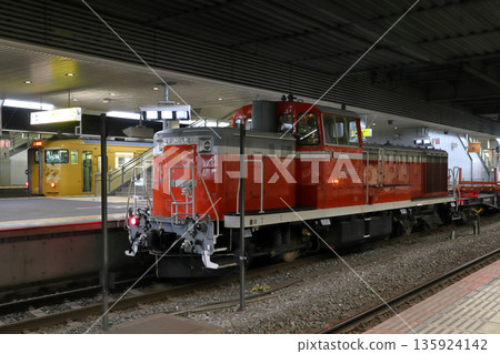 一列由DE10型柴油機車牽引的鐵路運輸列車停靠在山陽本線岡山站。 135924142