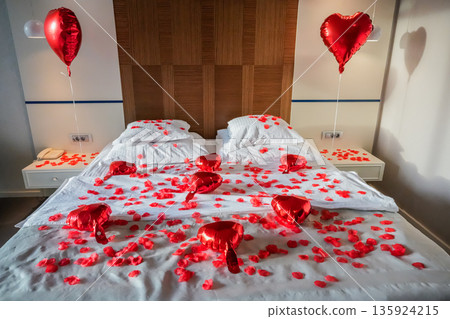 Bed Covered with Rose Petals and Heart Balloons Bed Covered with Rose Petals and Heart Balloons 135924215