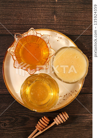 Variety of honey varieties cups on the kitchen table.Assortment of meadow, flower, bee honey and nectar for banner at honey fair or sale,natural healthy product for health and treatment, Variety of honey varieties cups on the kitchen table.Assortment of meadow, flower, bee honey and nectar for banner at honey fair or sale,natural healthy product for health and treatment, 135924359