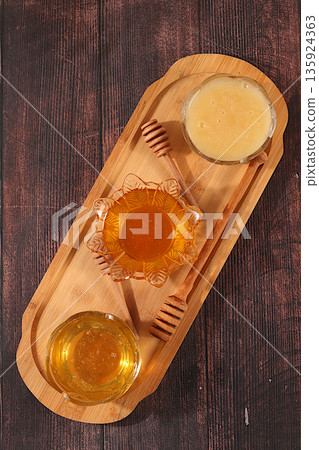 Variety of honey varieties cups on the kitchen table.Assortment of meadow, flower, bee honey and nectar for banner at honey fair or sale,natural healthy product for health and treatment, Variety of honey varieties cups on the kitchen table.Assortment of meadow, flower, bee honey and nectar for banner at honey fair or sale,natural healthy product for health and treatment, 135924363
