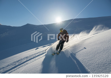 Off-piste freeride skiing on fresh powder with friends and a female helicopter pilot 135925120
