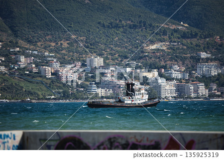 An evening view of the coastline of Vlora, Albania, taken in August 2025. Soft sunlight illuminates the rocky hills and seascape. An evening view of the coastline of Vlora, Albania, taken in August 2025. Soft sunlight illuminates the rocky hills and seascape. 135925319