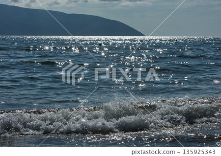 An evening view of the coastline of Vlora, Albania, taken in August 2025. Soft sunlight illuminates the rocky hills and seascape. An evening view of the coastline of Vlora, Albania, taken in August 2025. Soft sunlight illuminates the rocky hills and seascape. 135925343