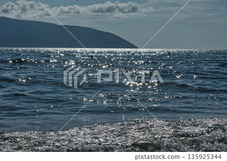 An evening view of the coastline of Vlora, Albania, taken in August 2025. Soft sunlight illuminates the rocky hills and seascape. An evening view of the coastline of Vlora, Albania, taken in August 2025. Soft sunlight illuminates the rocky hills and seascape. 135925344