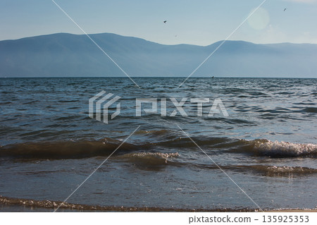 An evening view of the coastline of Vlora, Albania, taken in August 2025. Soft sunlight illuminates the rocky hills and seascape. An evening view of the coastline of Vlora, Albania, taken in August 2025. Soft sunlight illuminates the rocky hills and seascape. 135925353