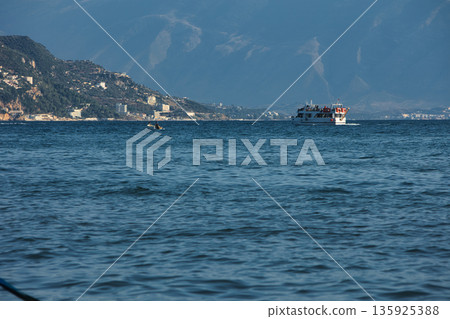 An evening view of the coastline of Vlora, Albania, taken in August 2025. Soft sunlight illuminates the rocky hills and seascape. An evening view of the coastline of Vlora, Albania, taken in August 2025. Soft sunlight illuminates the rocky hills and seascape. 135925388