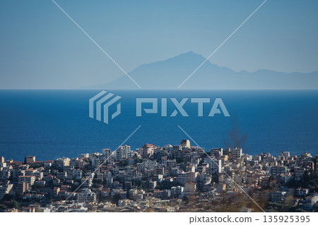 An evening view of the coastline of Vlora, Albania, taken in August 2025. Soft sunlight illuminates the rocky hills and seascape. An evening view of the coastline of Vlora, Albania, taken in August 2025. Soft sunlight illuminates the rocky hills and seascape. 135925395