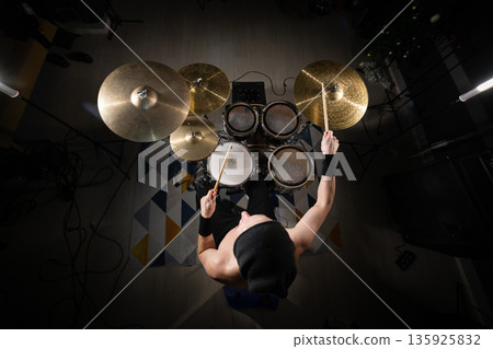 Drummer playing powerful rhythm on a professional drum kit 135925832