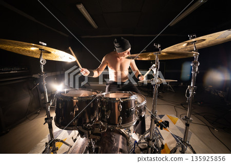 Energetic man drumming on stage creating rhythm 135925856