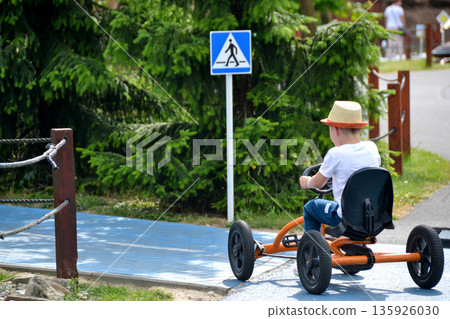 boy driving quad bike, four wheel cycle car, spring brightly morning, sunny day. High quality photo boy driving quad bike, four wheel cycle car, spring brightly morning, sunny day. High quality photo 135926030
