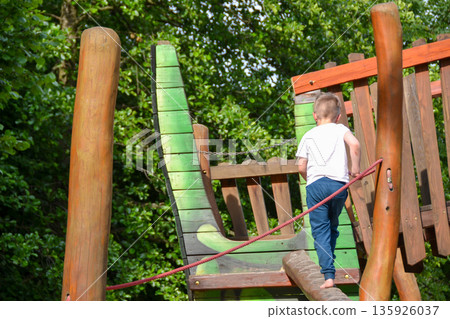 life of children in a modern city - little boy is having fun on the playground near the house. High quality photo life of children in a modern city - little boy is having fun on the playground near the house. High quality photo 135926037
