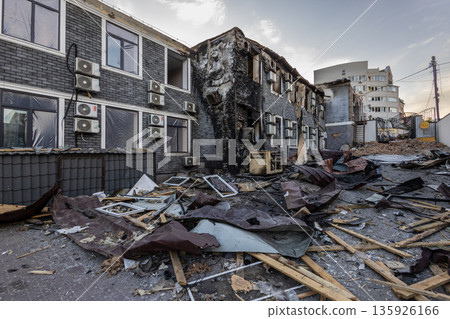 Charred multi story building with broken windows, scattered debris, and intact air conditioners scene of localized fire damage amid urban surroundings. Charred multi story building with broken windows, scattered debris, and intact air conditioners scene of localized fire damage amid urban surroundings. 135926166