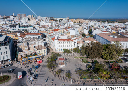 The image shows the old town area of Faro with buildings, streets, and the nearby docks. Visitors can see Ria Formosa and the busy atmosphere of the city The image shows the old town area of Faro with buildings, streets, and the nearby docks. Visitors can see Ria Formosa and the busy atmosphere of the city 135926318