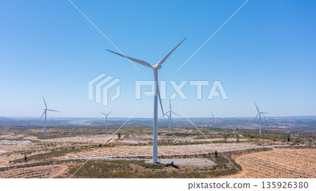 Wind green energy. Wind turbines stand tall against a clear blue sky, showcasing renewable energy potential and ecological innovation for a sustainable future Wind green energy. Wind turbines stand tall against a clear blue sky, showcasing renewable energy potential and ecological innovation for a sustainable future 135926380