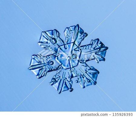 Natural snowflake crystal in blue background Natural snowflake crystal in blue background 135926393