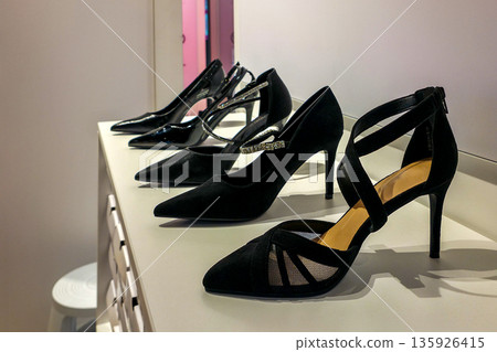 Elegant black high heel shoes displayed on a fashion boutique shelf in a modern retail store Elegant black high heel shoes displayed on a fashion boutique shelf in a modern retail store 135926415