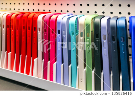 Colorful smartphone cases neatly displayed on a retail shelf in a modern electronics store Colorful smartphone cases neatly displayed on a retail shelf in a modern electronics store 135926416