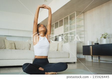 Yoga fitness workout training. Healthy African girl practicing yoga at home. Woman training Pilates doing sports exercise on yoga mat indoor. Girl have training workout for weight loss. Sport fitness Yoga fitness workout training. Healthy African girl practicing yoga at home. Woman training Pilates doing sports exercise on yoga mat indoor. Girl have training workout for weight loss. Sport fitness 135926445