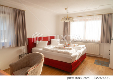 Comfortable hotel bedroom with neatly made bed and soft daylight. Minimal interior designed for rest, relaxation and travel accommodation Comfortable hotel bedroom with neatly made bed and soft daylight. Minimal interior designed for rest, relaxation and travel accommodation 135926649