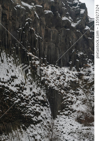 Snow-covered basalt columns form dramatic vertical patterns at the Symphony of Stones, dark volcanic rock contrasts with white winter textures Snow-covered basalt columns form dramatic vertical patterns at the Symphony of Stones, dark volcanic rock contrasts with white winter textures 135927324