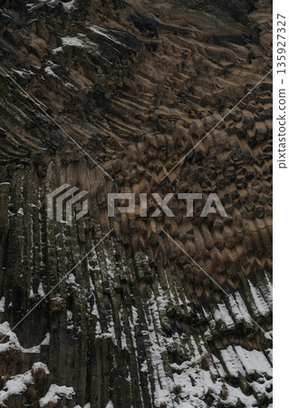 Vertical basalt columns create dense geometric textures at Symphony of Stones, dark volcanic rock contrasts with scattered snow Vertical basalt columns create dense geometric textures at Symphony of Stones, dark volcanic rock contrasts with scattered snow 135927327