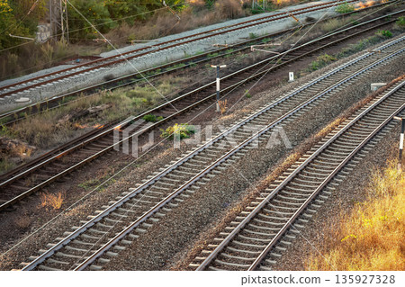 Railway tracks and transport infrastructure. Multiple railway tracks with gravel and overhead electric lines. Transportation, logistics, railway infrastructure, industry, mobility concept 135927328