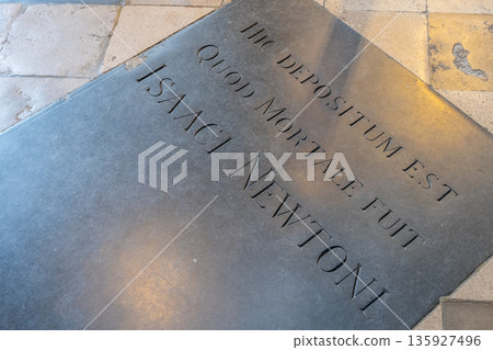 A stone memorial marks the resting place of Sir Isaac Newton in Westminster Abbey, London. Visitors come to pay their respects at this historic site in the United Kingdom. 135927496