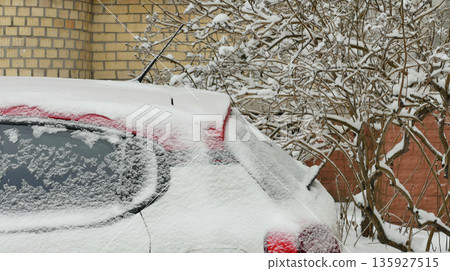 A side view of the rear of a car covered in snow in a parking lot in front of a residential building. Car Covered in Snow at Street Parking Stock Photo A side view of the rear of a car covered in snow in a parking lot in front of a residential building. Car Covered in Snow at Street Parking Stock Photo 135927515
