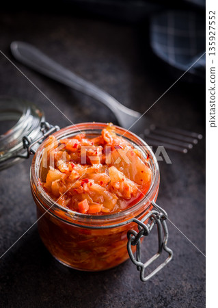 Fermented cabbage. Kimchi. Korean food in jar on black table. Fermented cabbage. Kimchi. Korean food in jar on black table. 135927552