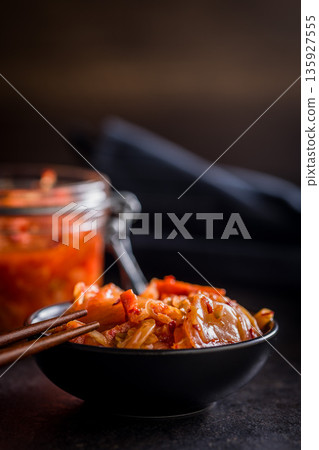 Fermented cabbage. Kimchi. Korean food in bowl on black table. 135927555