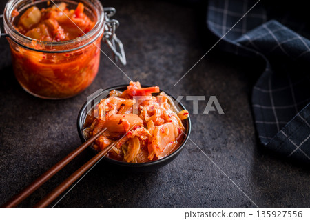 Fermented cabbage. Kimchi. Korean food in bowl on black table. 135927556
