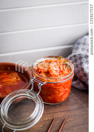 Fermented cabbage. Kimchi. Korean food in jar on wooden table. Fermented cabbage. Kimchi. Korean food in jar on wooden table. 135927557