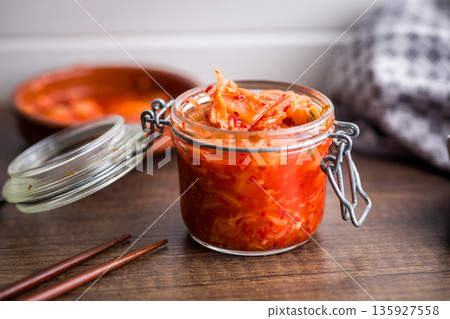 Fermented cabbage. Kimchi. Korean food in jar on wooden table. 135927558