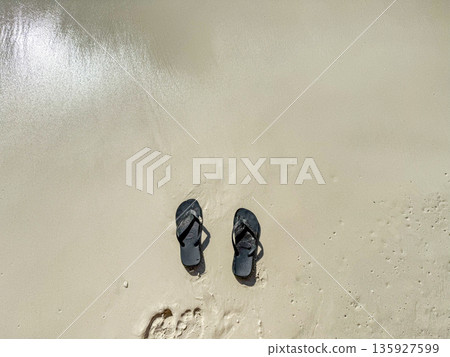 Flip Flops on Wet Sandy Beach 135927599