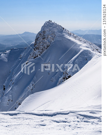 Mt. Tanigawa in the dead of winter. Toma-no-mimi seen from Oki-no-mimi and the silhouette of climbers. 135928134